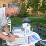 Maria Stolz stempelt eine Urkunde für die bestandene Prüfung zum „Ehren-Telegraphisten“ auf der Station Nr. 4